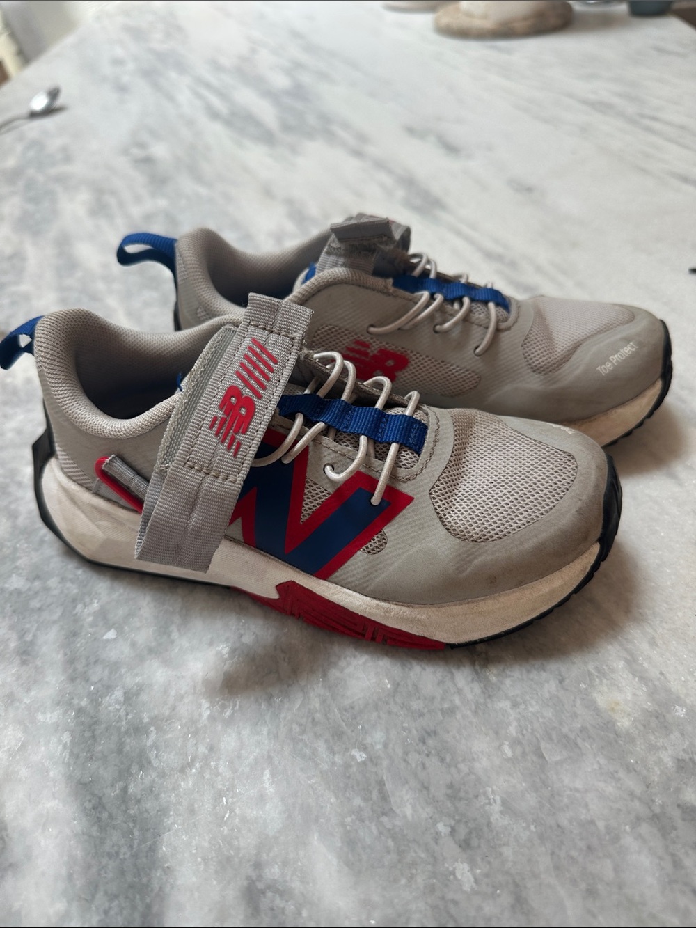 New Balance Kids Gray Sneakers with Blue and Red Accents